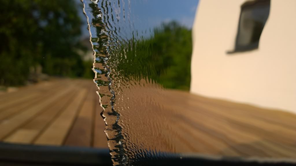 Blick durch die Wasserwand auf die Holzterrasse